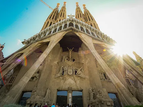 Fachada de la Sagrada Familia en Barcelona iluminada por el sol desde un ángulo bajo