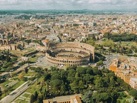 Vista aérea del Coliseo de Roma y su entorno urbano en un día soleado
