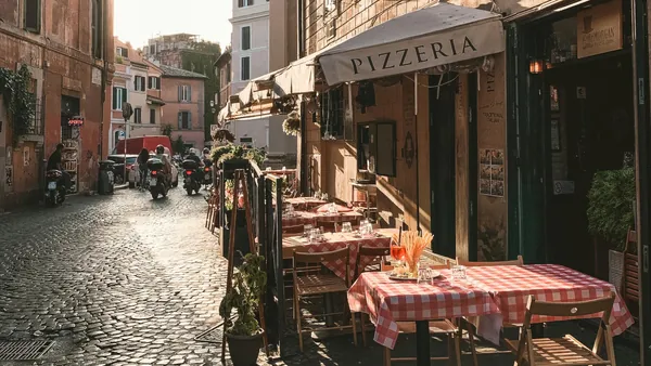 Calle de Trastevere con una pizzeria, una de las paradas del tour de comida italiana en Trastevere.