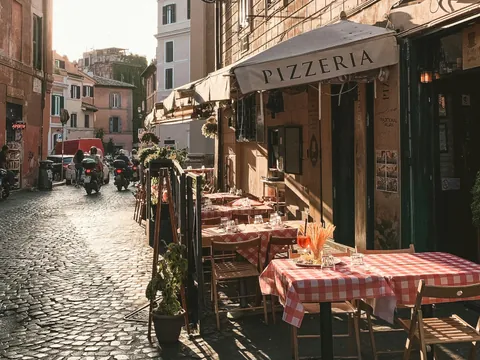 Calle de Trastevere con una pizzeria, una de las paradas del tour de comida italiana en Trastevere.