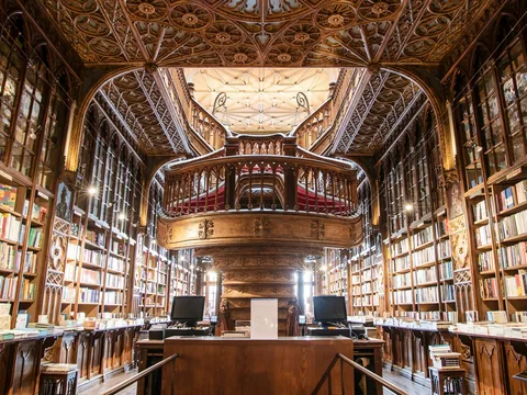 Interior de la Librería Lello en Oporto con escaleras y detalles de madera tallada.