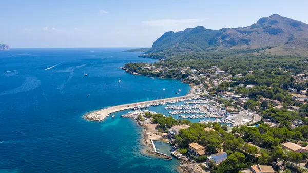 Panorámica de la costa de Alcudia, con sus aguas cristalinas, playas de arena dorada y un paisaje natural impresionante que se extiende hacia el horizonte.