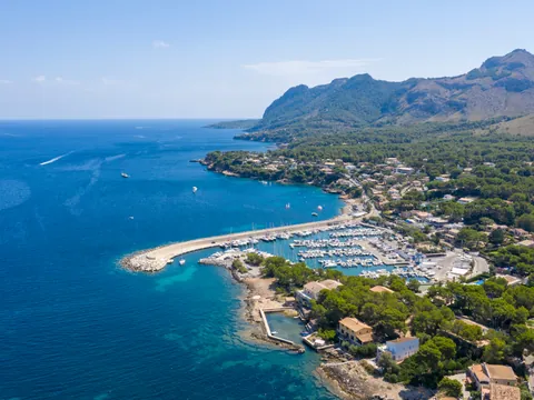 Panorámica de la costa de Alcudia, con sus aguas cristalinas, playas de arena dorada y un paisaje natural impresionante que se extiende hacia el horizonte.
