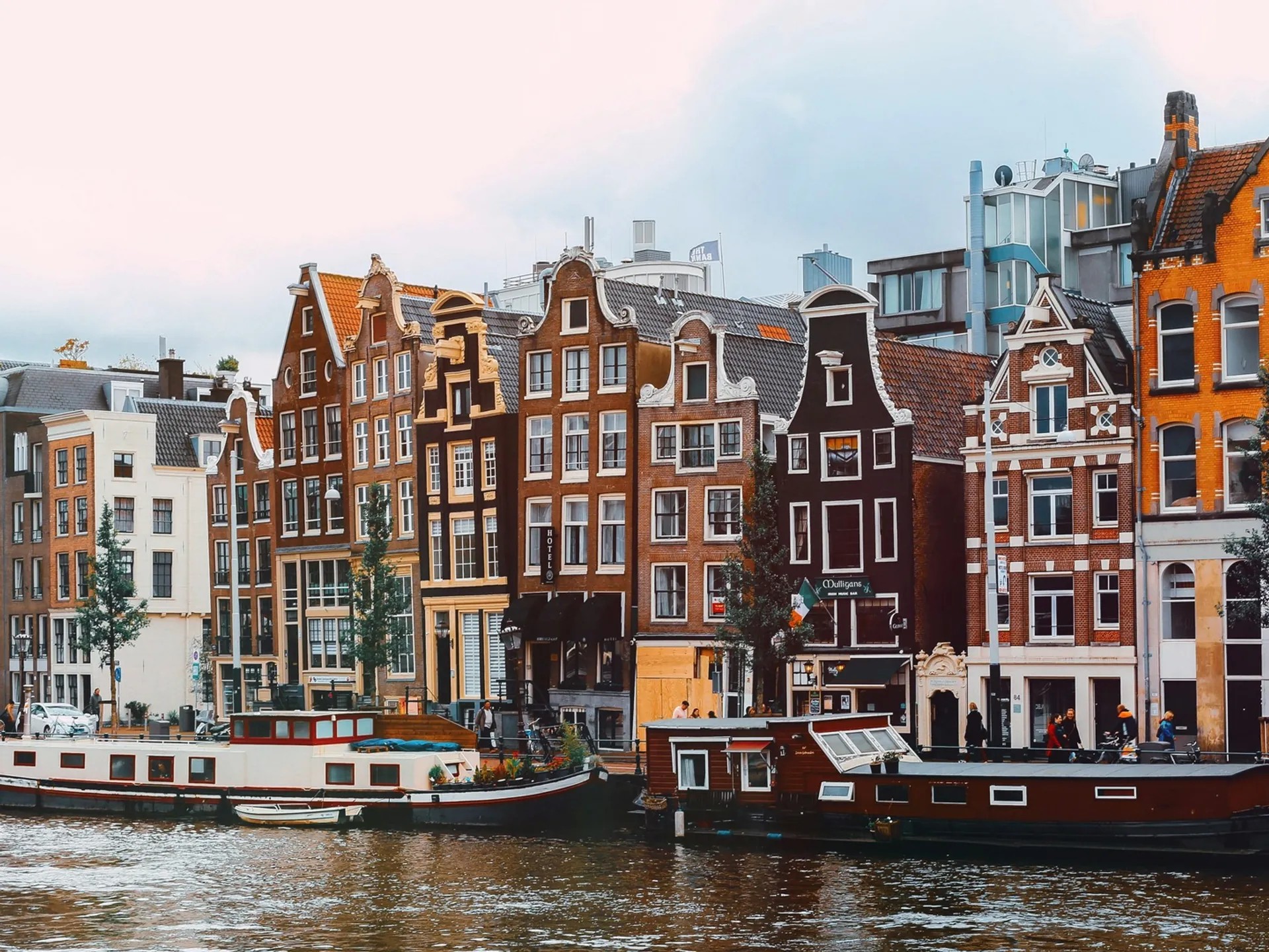 Casas flotantes y fachadas tradicionales junto a un canal en Ámsterdam.