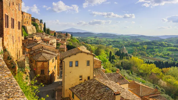 Vista panorámica desde un mirador en Montepulciano, con colinas verdes salpicadas de árboles y parte del pueblo