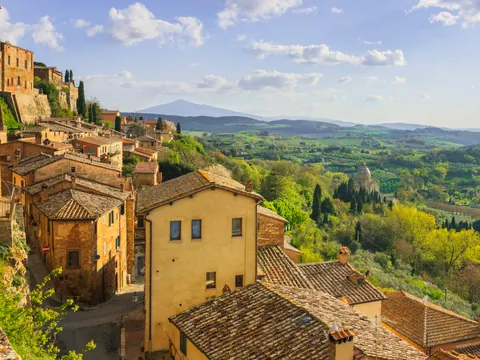 Vista panorámica desde un mirador en Montepulciano, con colinas verdes salpicadas de árboles y parte del pueblo