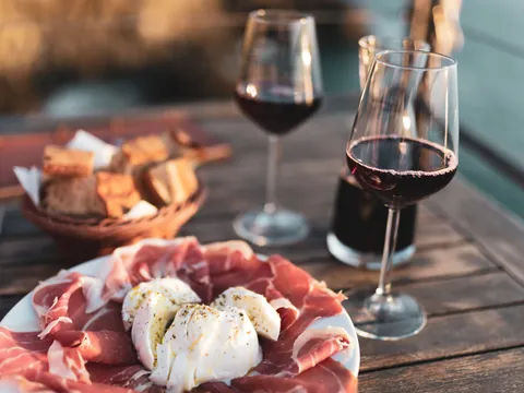 Aperitivo italiano compuesto de embutido, queso y vino de Chianti