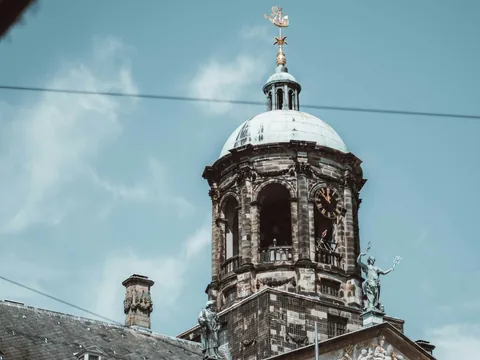 Cúpula del Palacio Real en la Plaza Dam de Ámsterdam bajo un cielo azul