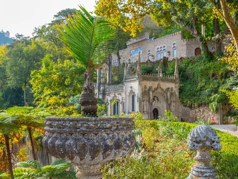 Jardines y fachada decorada de Quinta da Regaleira en un entorno verde de Sintra