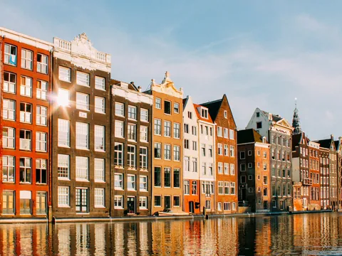 Casas típicas reflejadas en los canales de Ámsterdam al atardecer