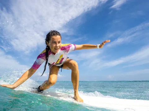 Clase de surf en Llanes, Asturias, con surfista sobre la ola