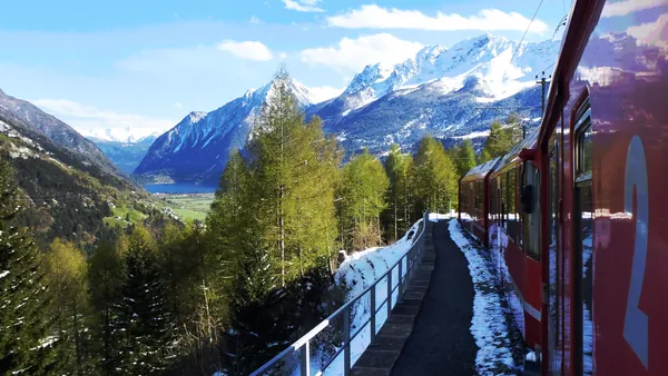 Tren Bernina pasando entre montañas y paisajes nevados de camino a Tirano.