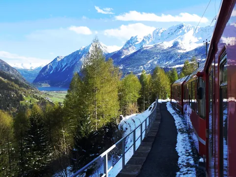 Tren Bernina pasando entre montañas y paisajes nevados de camino a Tirano.