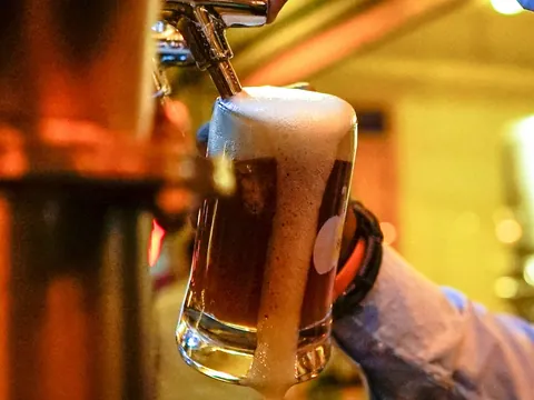 Cerveza artesanal con espuma desbordando el vaso tirada de un grifo en Berlín.