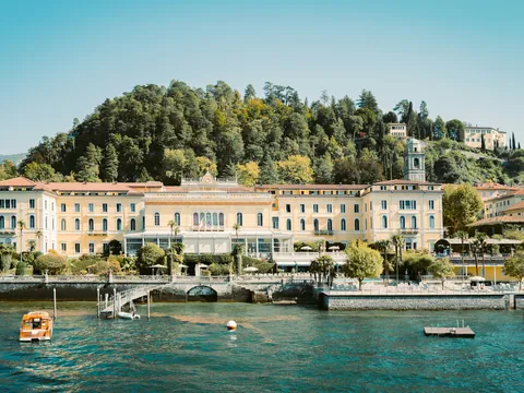 Fachada del Grand Hotel en el Lago di Como frente al agua y colinas boscosas