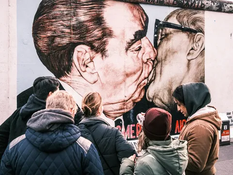 Turistas observando el famoso mural del beso en el Muro de Berlín