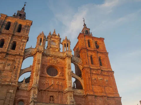 Fachada de la Catedral de Astorga, León, arquitectura gótica y barroca, torres gemelas al atardecer, contrapicada.