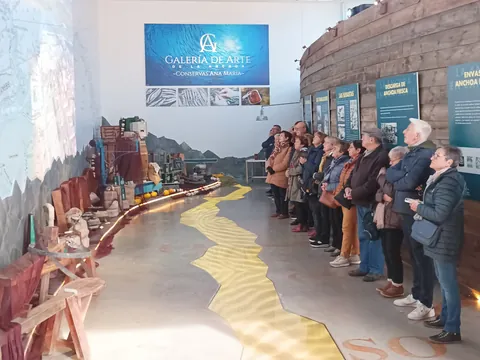 Interior de la Galería del Arte de la Anchoa con participantes recibiendo explicaciones.