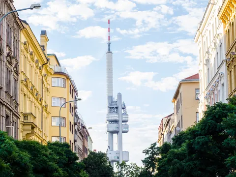 Torre de Televisión Žižkov encajada entre edificios de calles en Praga.