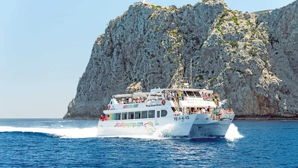 El barco navega suavemente hacia la majestuosa costa de Formentor, rodeado de aguas cristalinas.