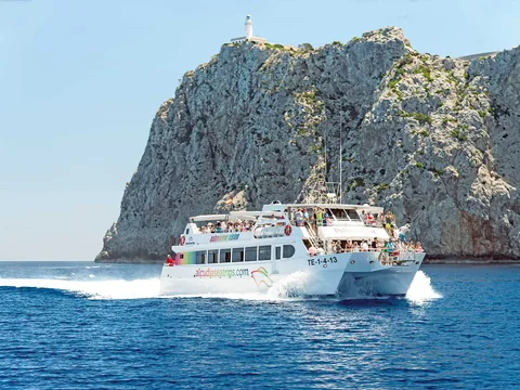 El barco navega suavemente hacia la majestuosa costa de Formentor, rodeado de aguas cristalinas.