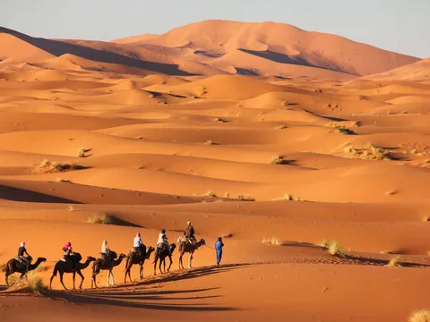 Paseo en camello al atardecer en el desierto de Merzouga, Marruecos