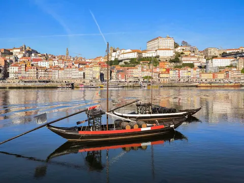 Barcos rabelos con barricas en el Duero frente a las casas de la Ribeira de Oporto