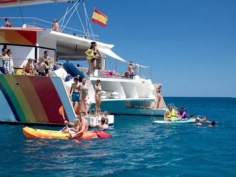 Bañistas disfrutando de un refrescante baño en el mar, con el agua clara y brillante bajo el sol.