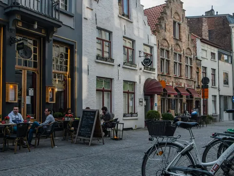 Personas sentadas en la terraza de un café en una calle de Brujas, Bélgica