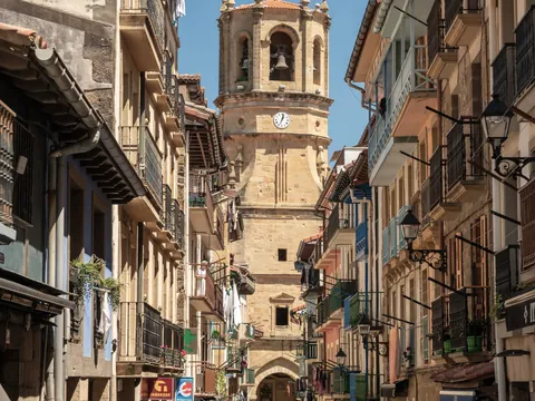 Calle principal de Getaria con casas tradicionales y torre de iglesia al fondo.