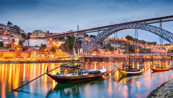Barcos rabelos en el río Duero con el puente Luis I al anochecer