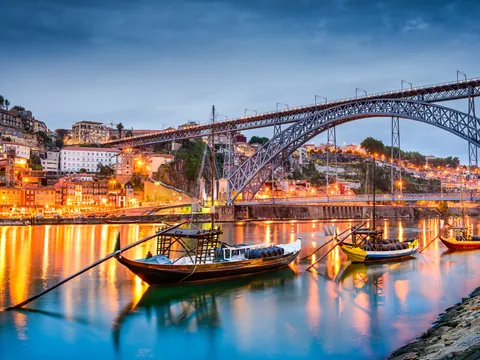 Barcos rabelos en el río Duero con el puente Luis I al anochecer