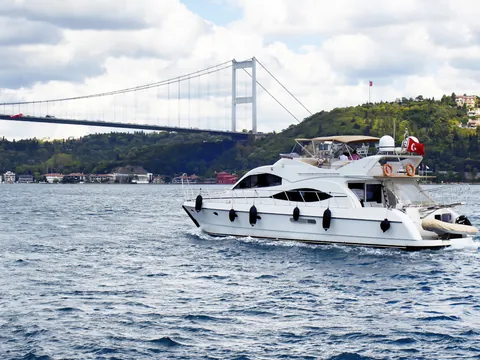 Yate de lujo navegando bajo un puente del Bósforo en Estambul, Turquía