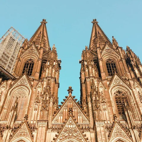 Torres gemelas de la Catedral de Colonia, Alemania, con detalles góticos y andamiaje en una de las fachadas.