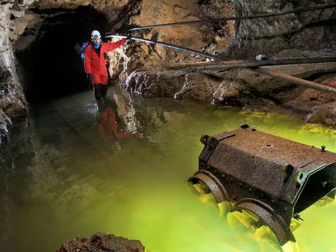 Exploración en la mina de El Soplao, Cantabria, con agua iluminada en la galería.