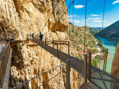 Puente colgante metálico del Caminito del Rey con vistas al embalse y las montañas