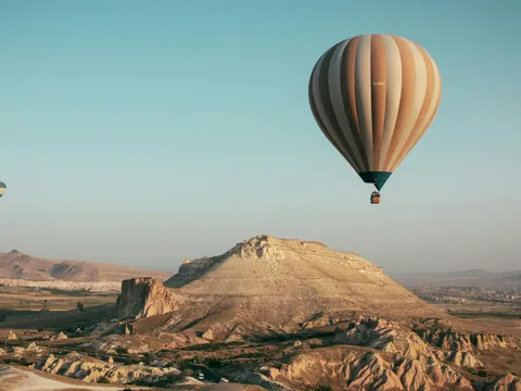 Globo aerostático sobre paisaje de Capadocia al amanecer, Turquía