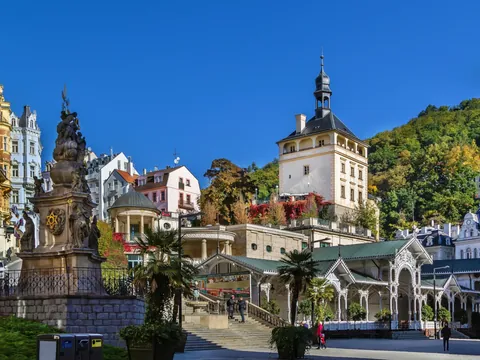 Estatua frente a la Torre del Mercado y arquitectura balnearia en Karlovy Vary