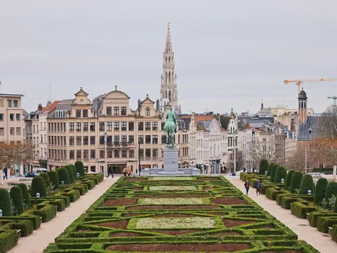 Vista del jardín Mont des Arts en Bruselas, con una estatua ecuestre en el centro y la torre del Ayuntamiento al fondo