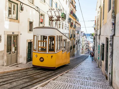 Ascensor da Bica descendiendo por su empinada calle en el centro de Lisboa.