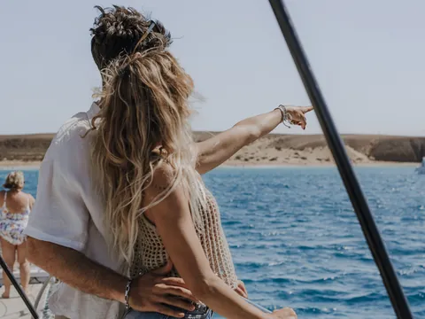 Una pareja contempla el horizonte desde la cubierta, compartiendo el momento con calma y sin prisa.