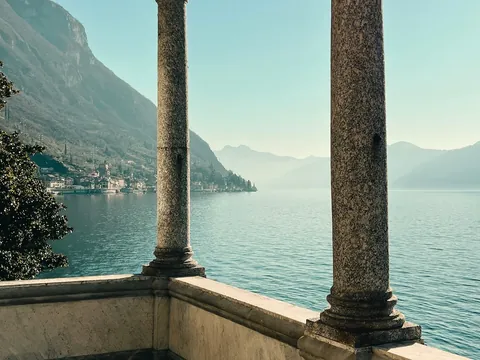 Vista del Lago di Como enmarcada por columnas de piedra desde una terraza