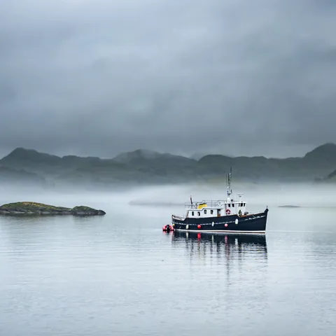 Lago Ness con barco y banco de niebla