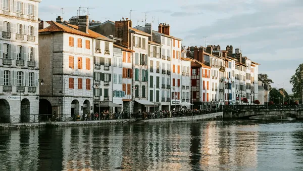Fachadas con contraventanas de colores junto al río en Bayona.
