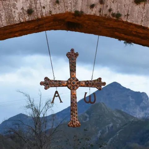 Detalle de la Cruz de la Victoria colgando del Puente Romano de Cangas de Onís, uno de los símbolos más icónicos de Asturias.