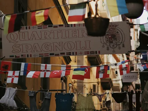 Cartel de entrada al barrio español, rodeado de banderines de países