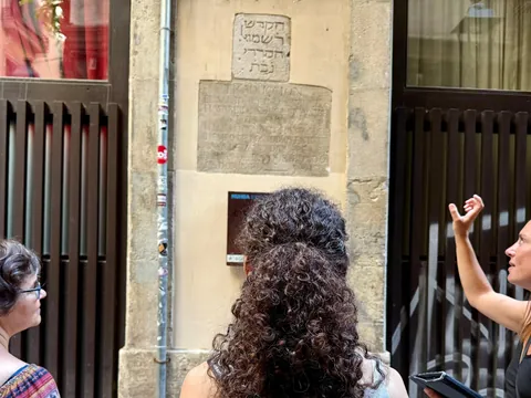 Guía turística explicando inscripción hebrea, Call de Barcelona