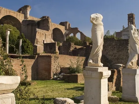 Estatuas y ruinas del Foro Romano en Roma, rodeadas de antiguos muros.