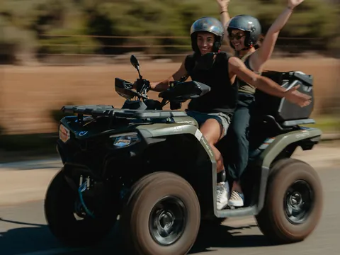 Diversión a bordo de un quad de una pareja sintiendo la adrenalina y la velocidad.