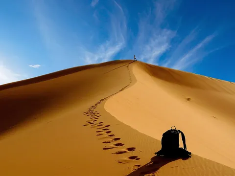 Dunas del desierto de Merzouga al atardecer con huellas sobre la arena